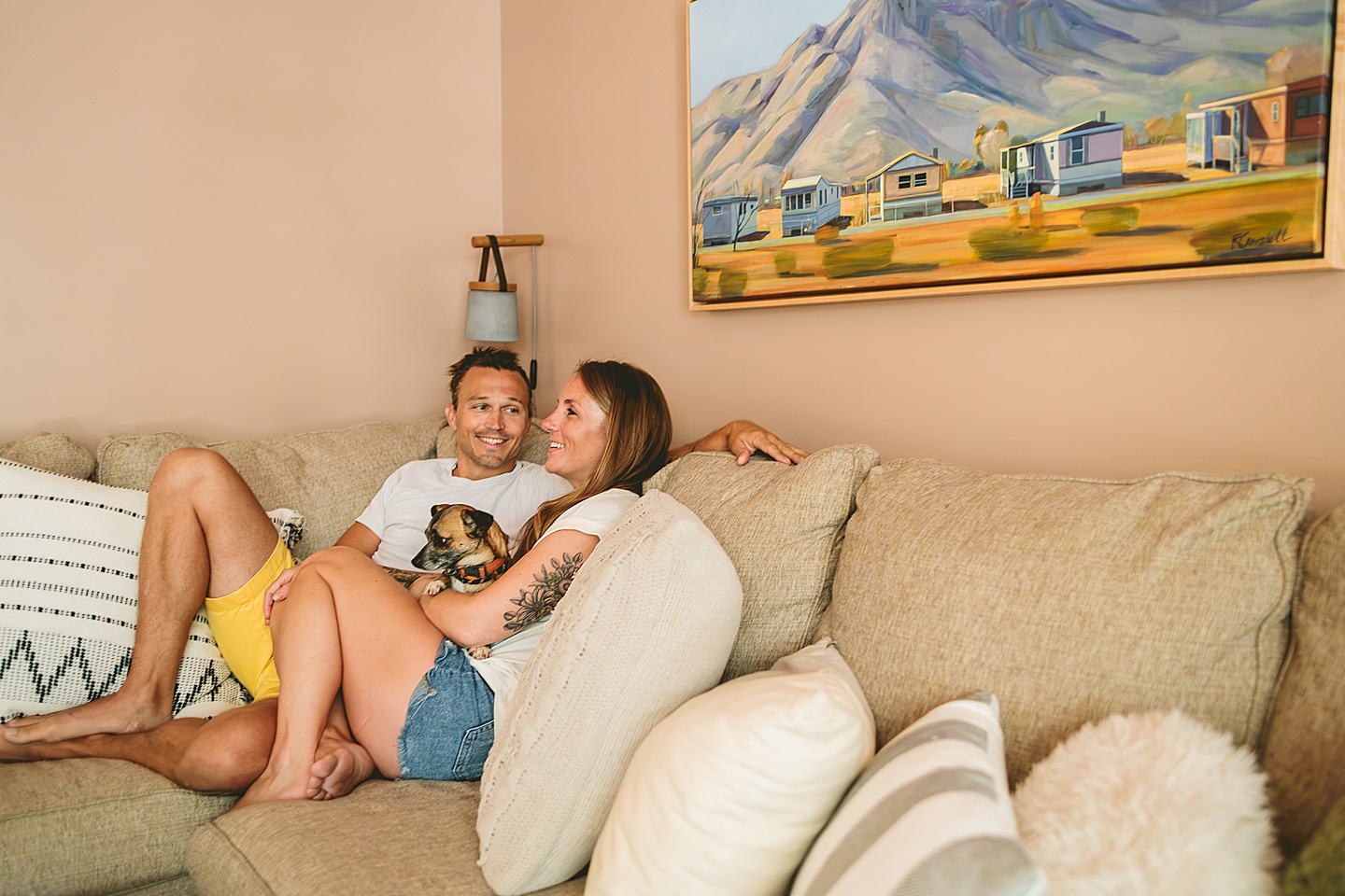 Couple sitting on their couch holding their small dog