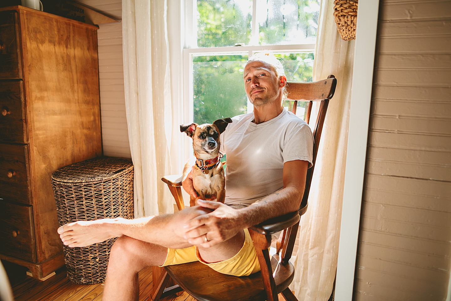 Man sitting in rocking chair holding dog