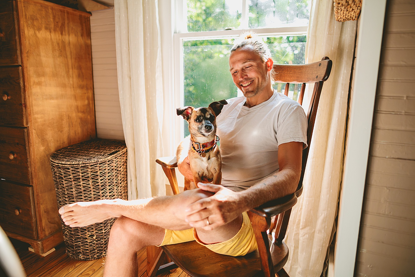 Man sitting in rocking chair holding dog