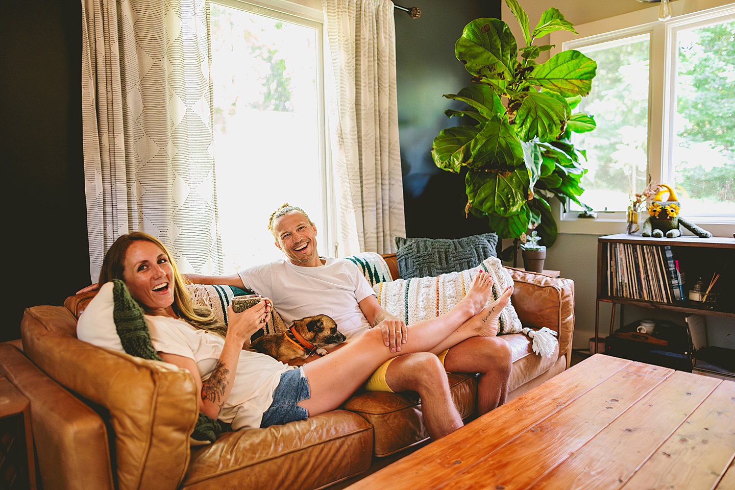 Couple sitting on couch with small dog at home in Hillsborough