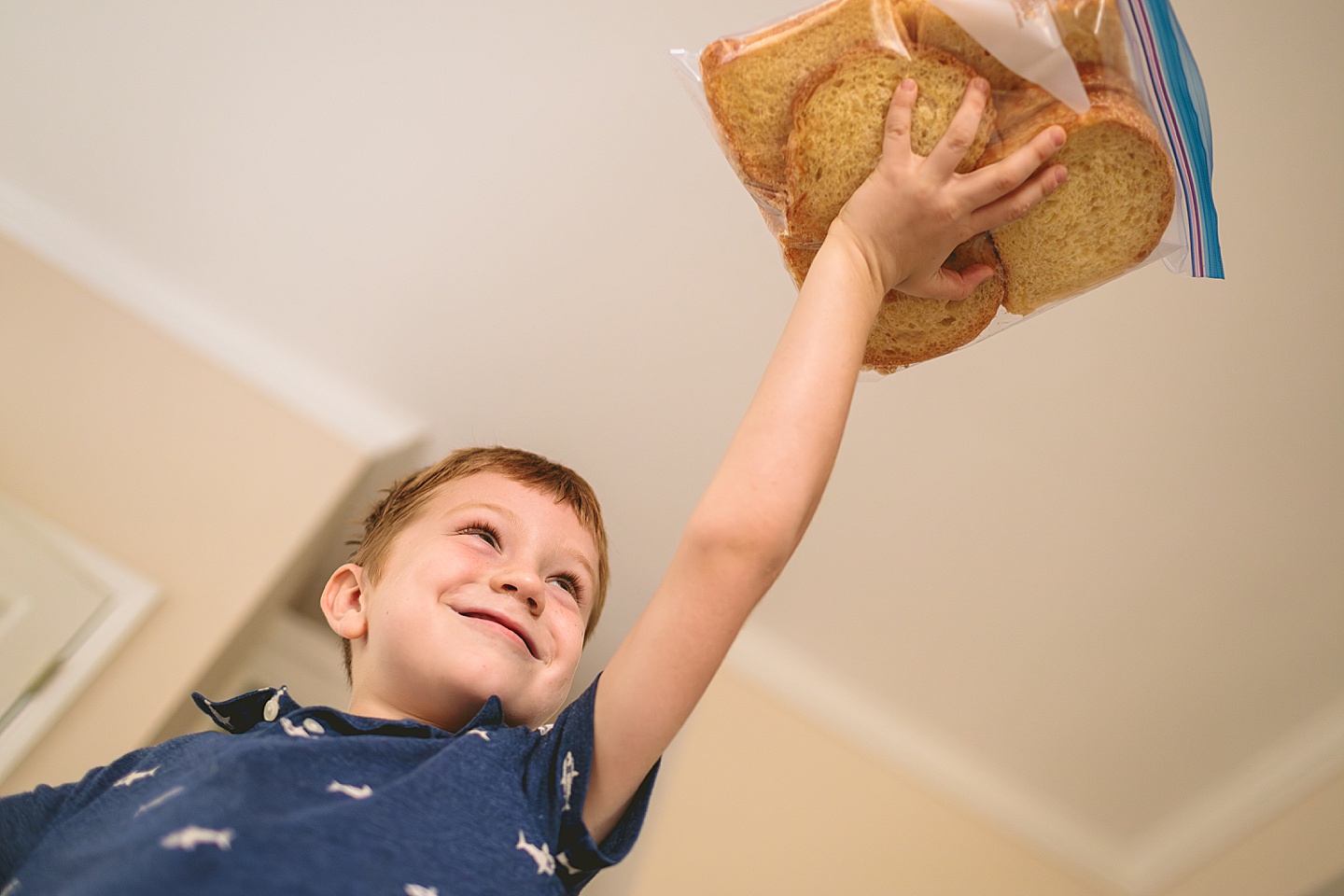 Kid holding up lots of bread