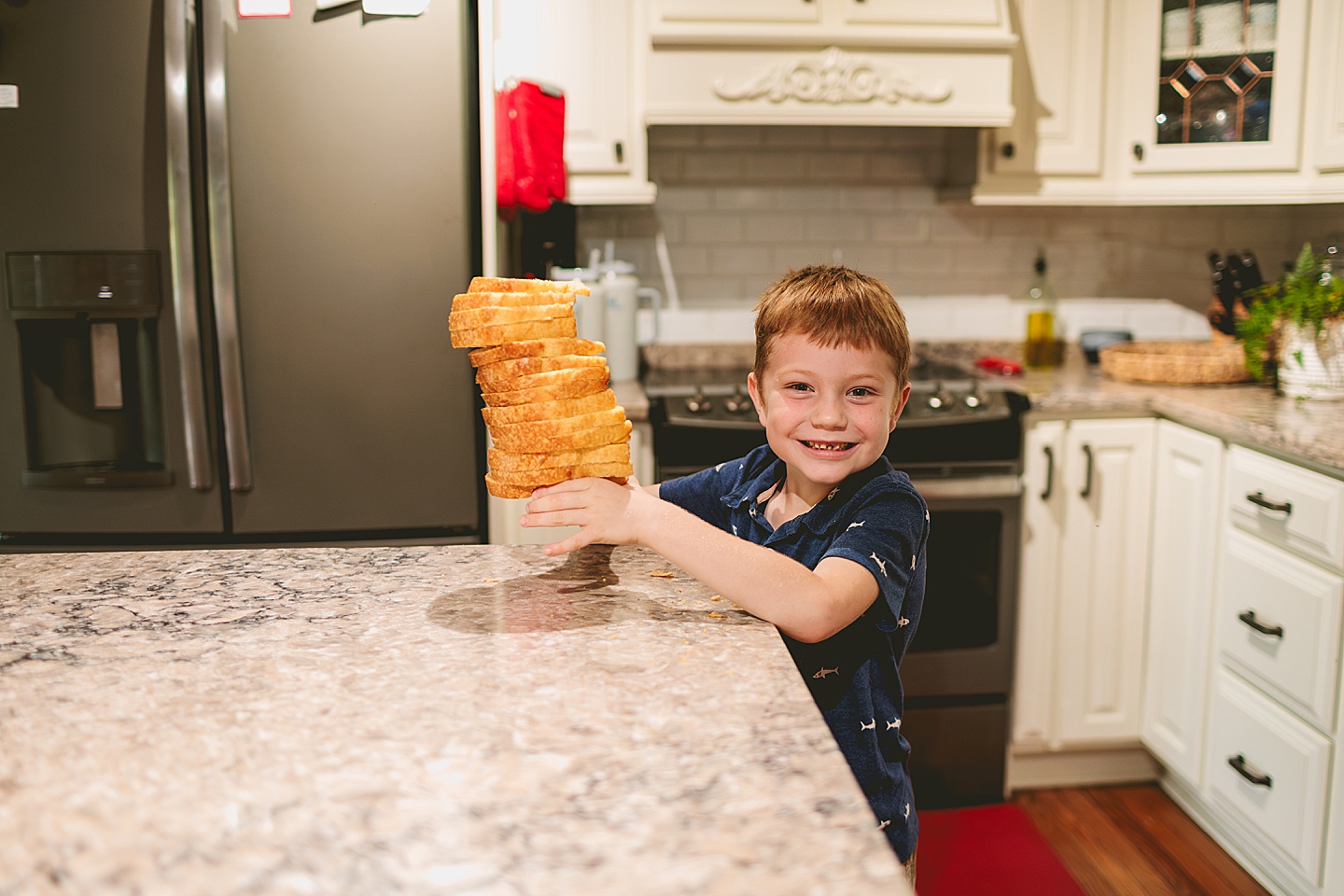 Kid holding up lots of bread