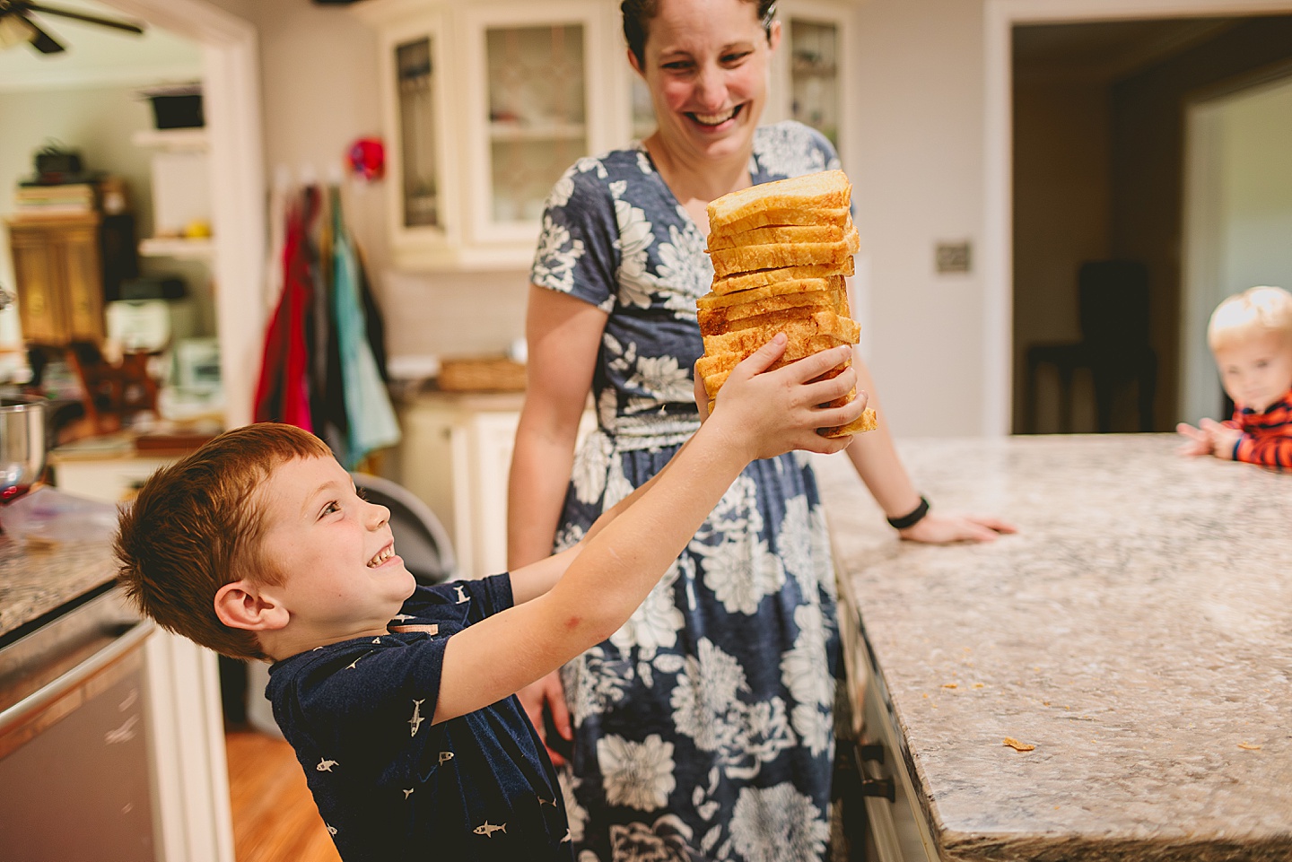Kid holding up lots of bread