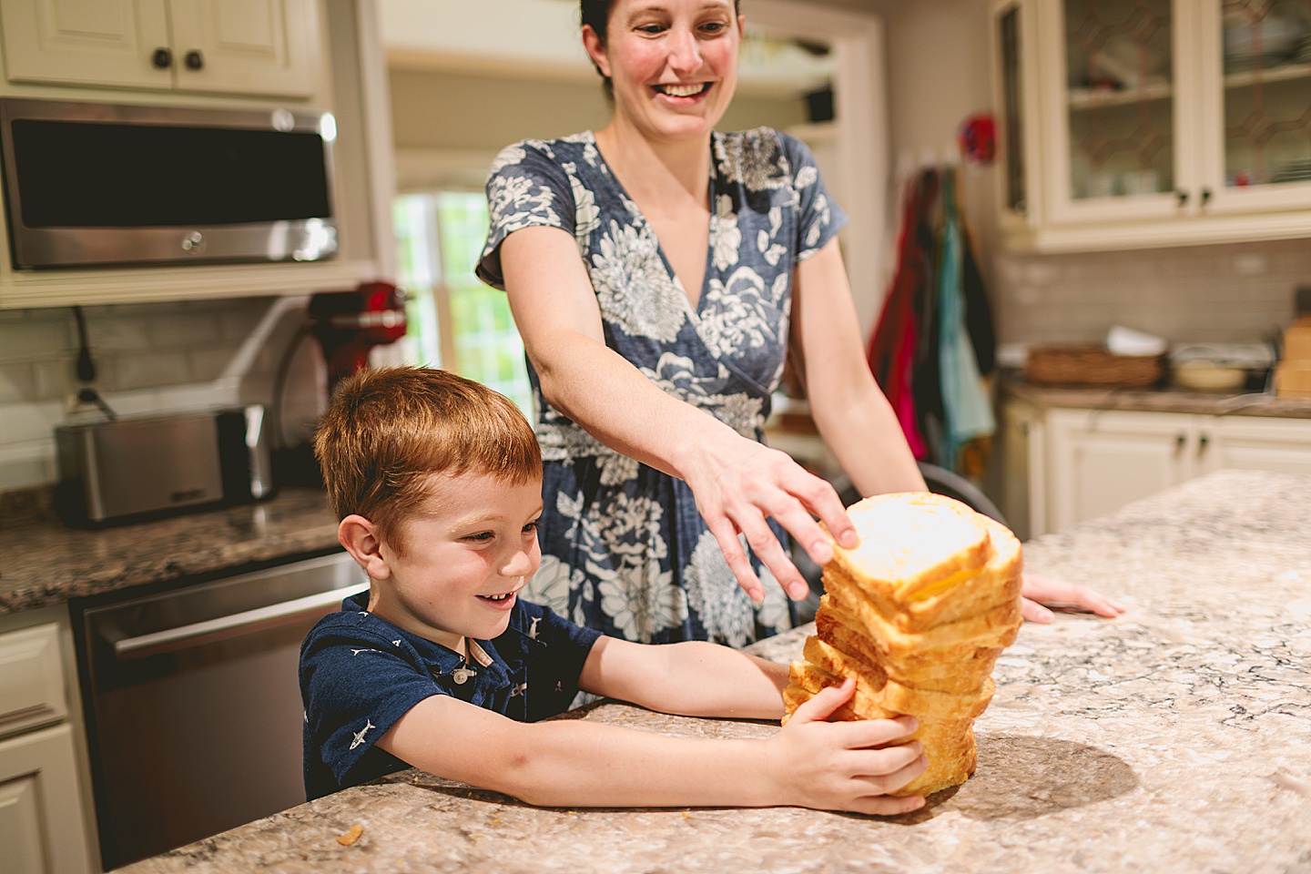 Kid holding up lots of bread