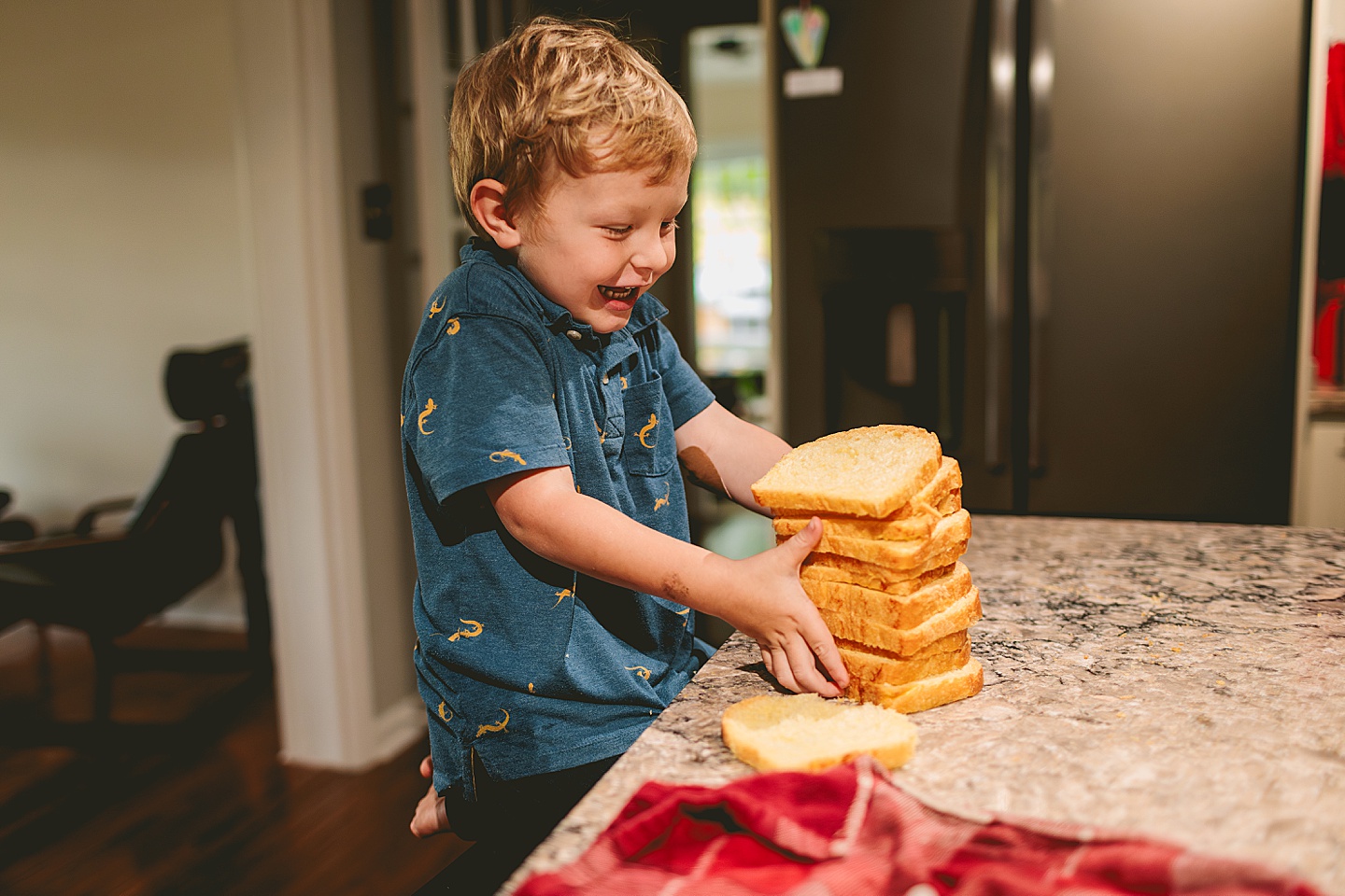 Kid holding up stack of bread