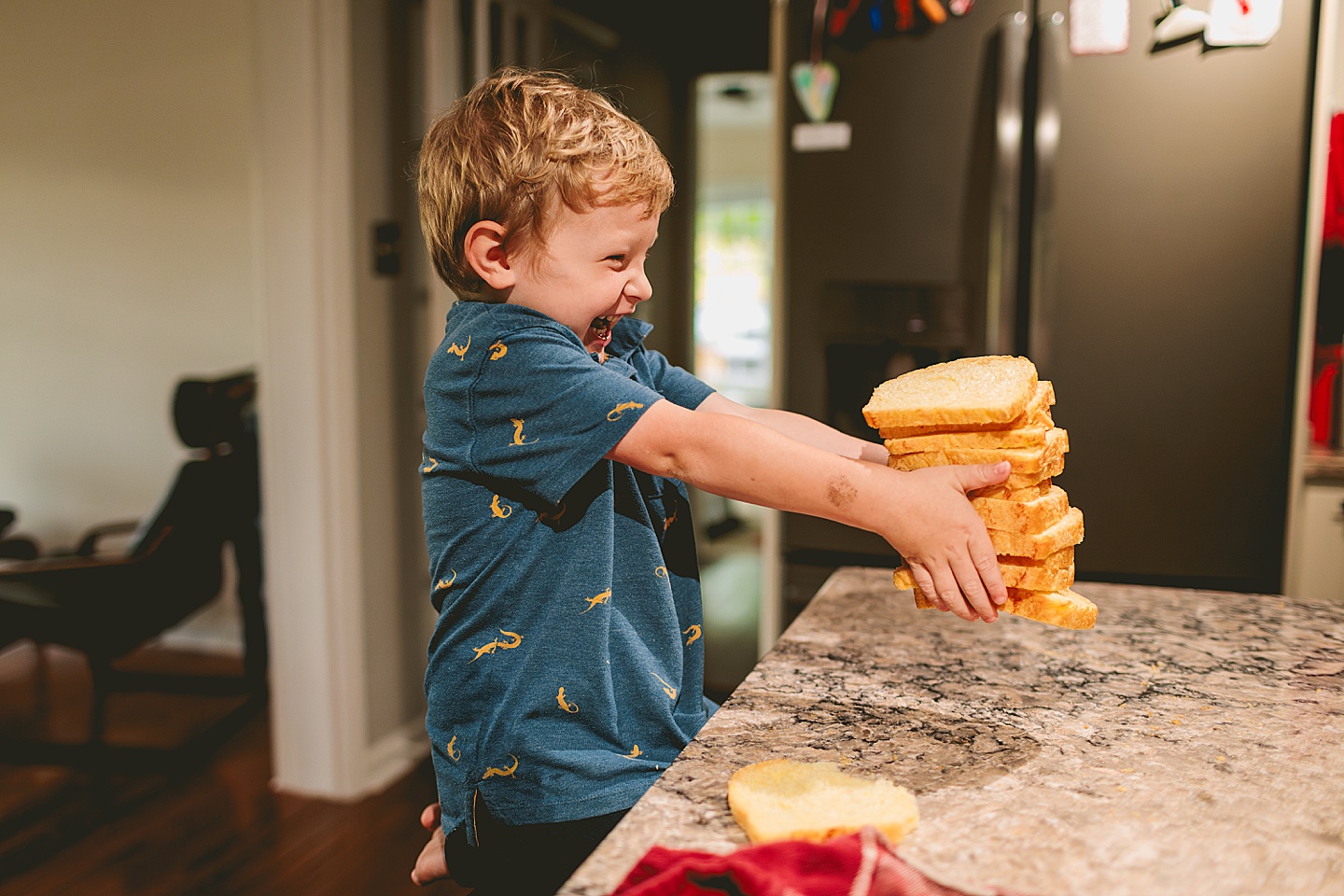 Kid holding up stack of bread