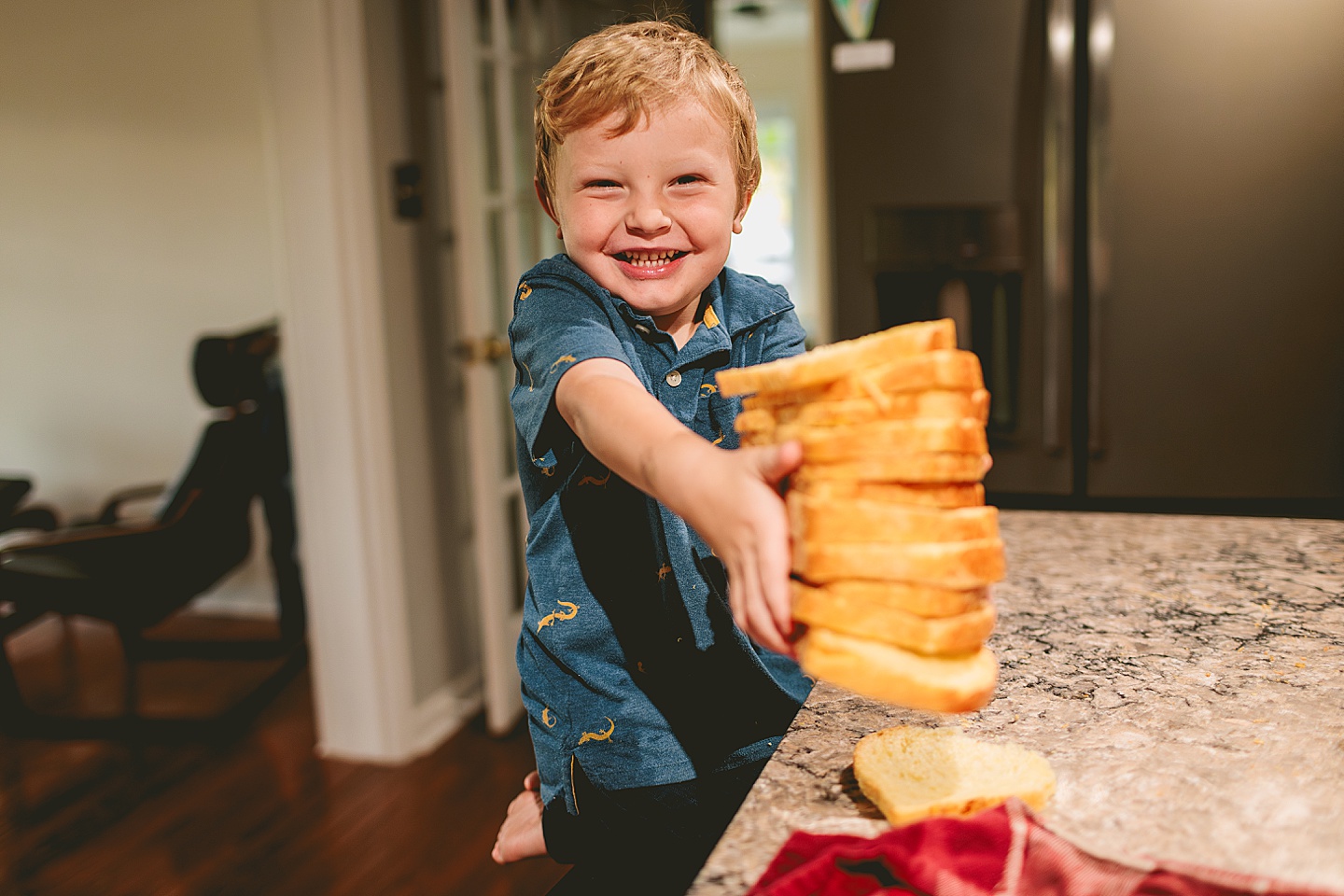 Kid holding up stack of bread