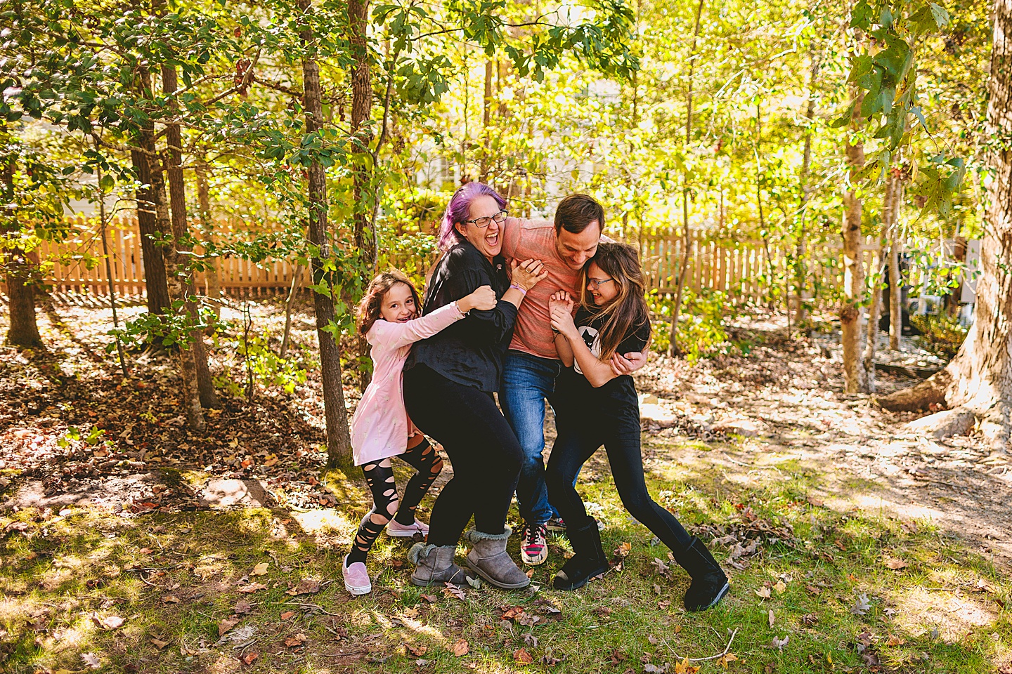 Family running and hugging in a backyard in Holly Springs