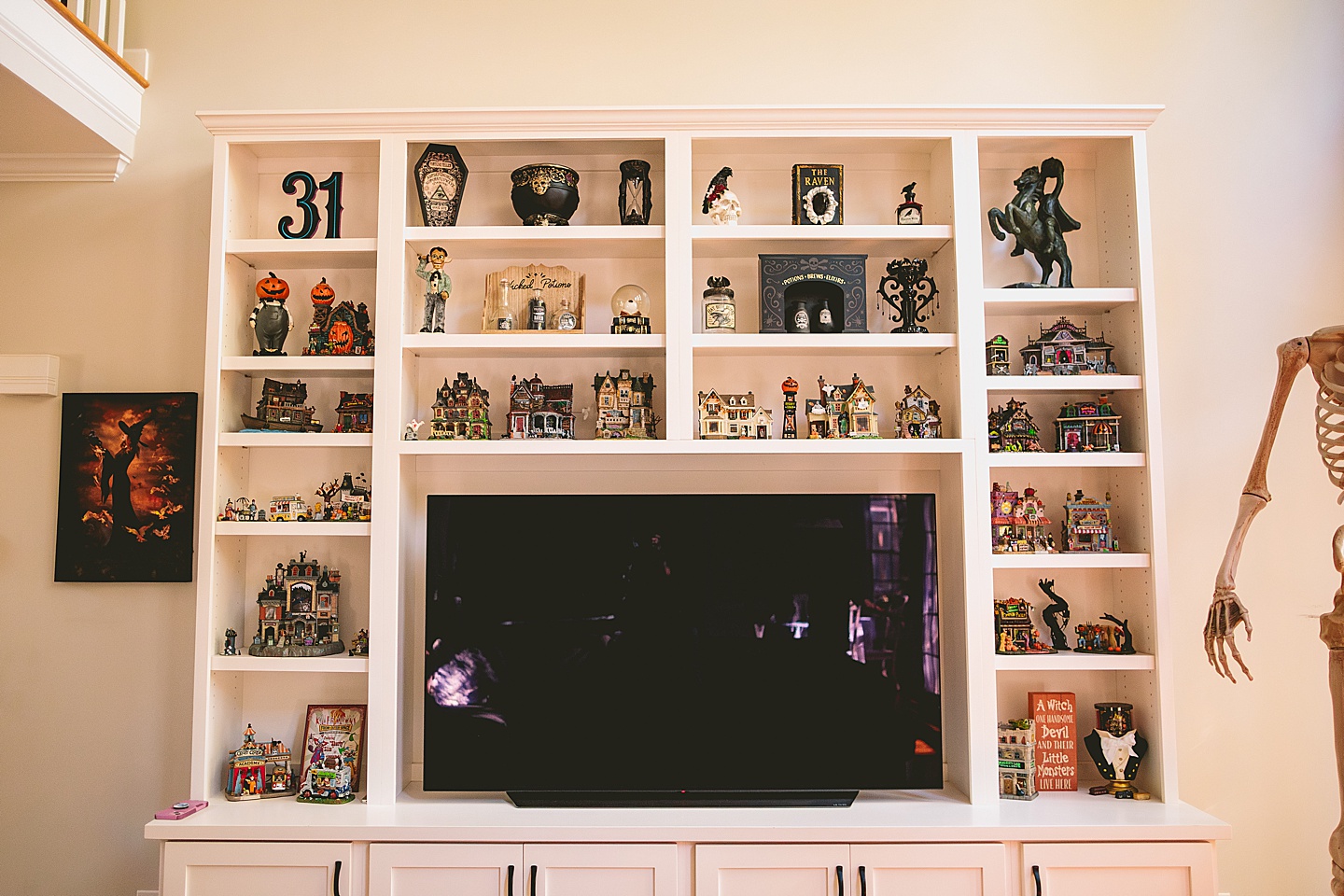Shelves around a TV covered in Halloween town houses
