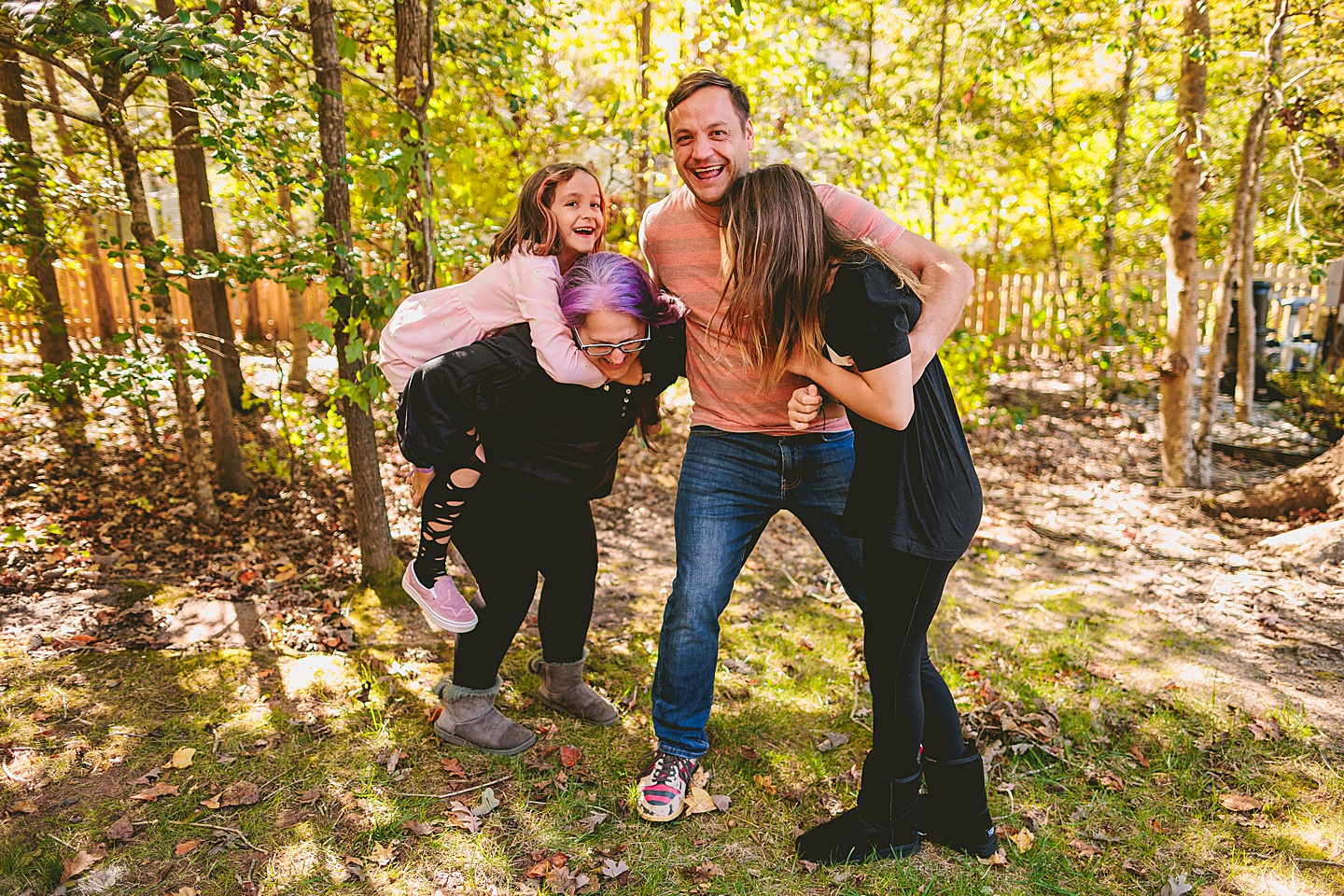 Family hugging and laughing in the backyard in Holly Springs