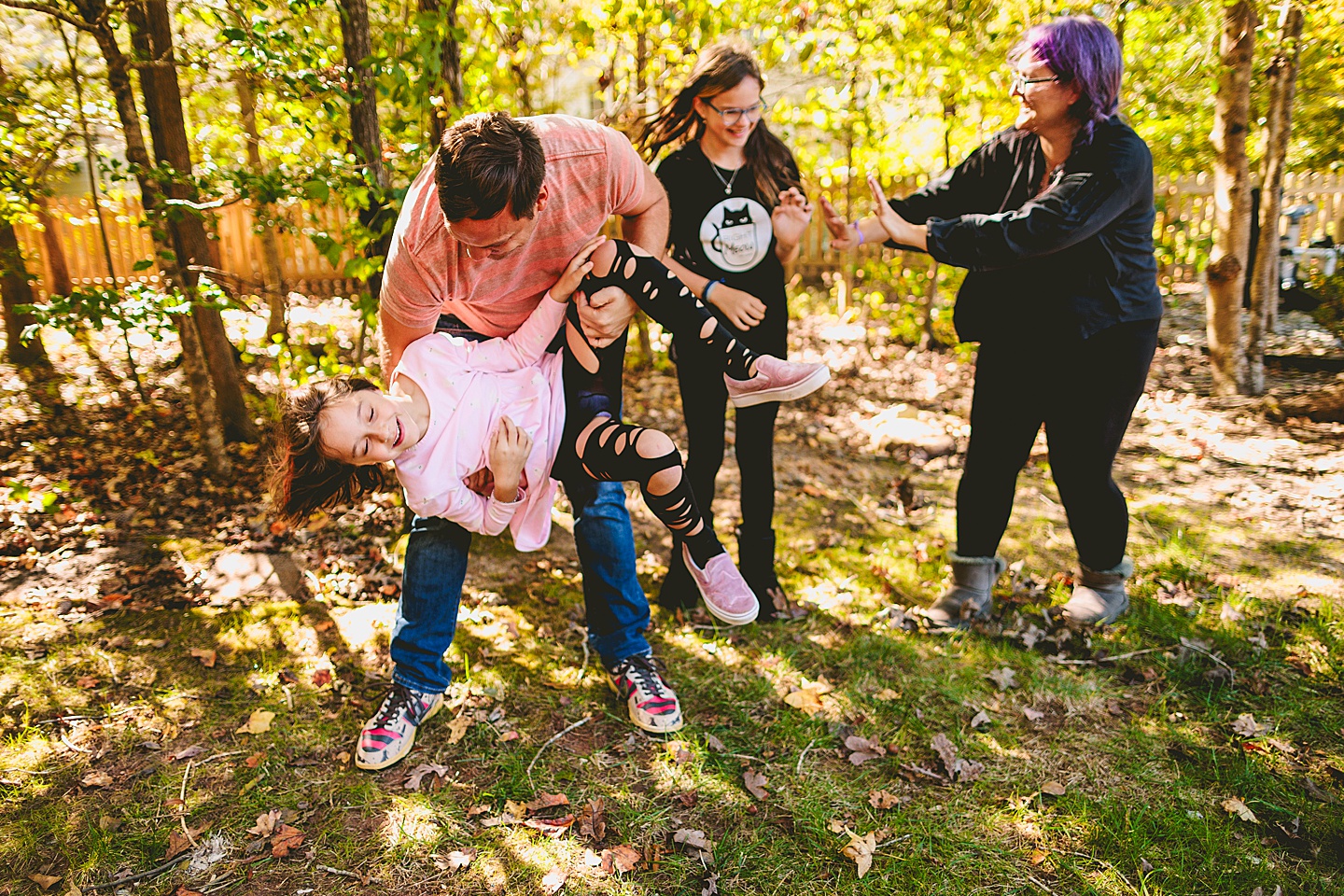 Picture of parents with their kids wrestling in the backyard in Holly Springs