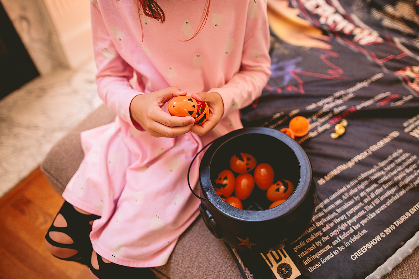 Girl opens up an orange Halloween egg with money inside