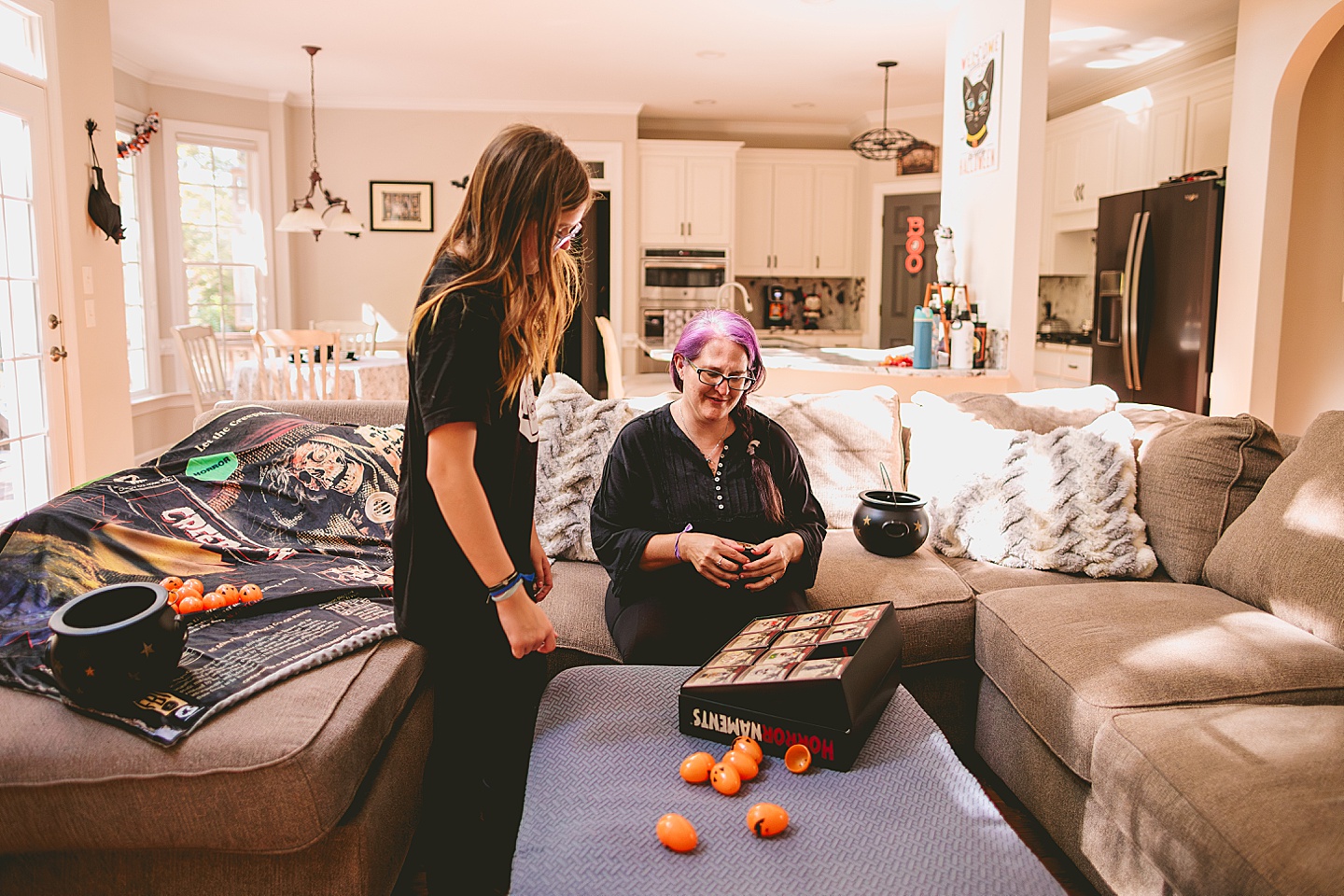 Mom shows daughter Halloween ornaments for tree