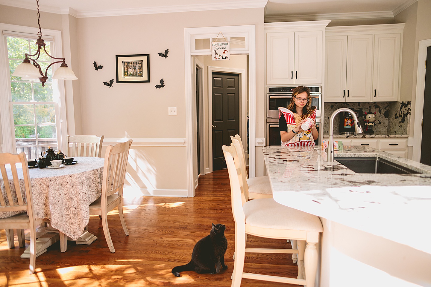 Girl prepares Ramen in kitchen while gray cat watches