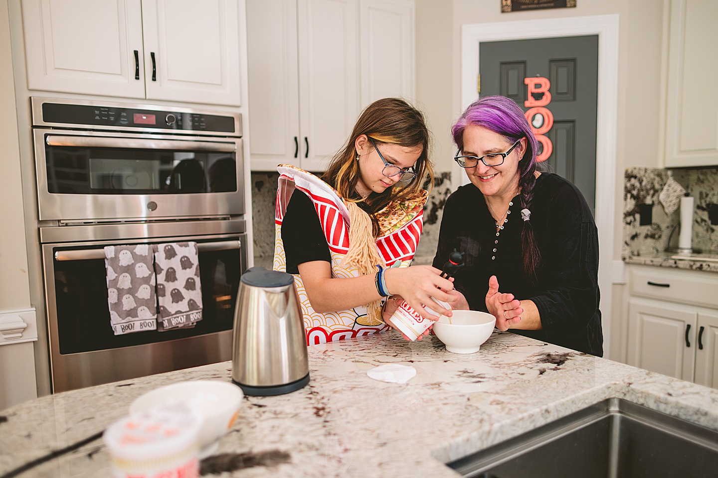 Mom helping daughter prepare noodle soup in the kitchen 